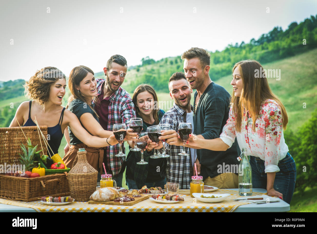 Gruppo di amici fare barbecue in natura - le persone felici divertendosi su un pic-nic in campagna Foto Stock
