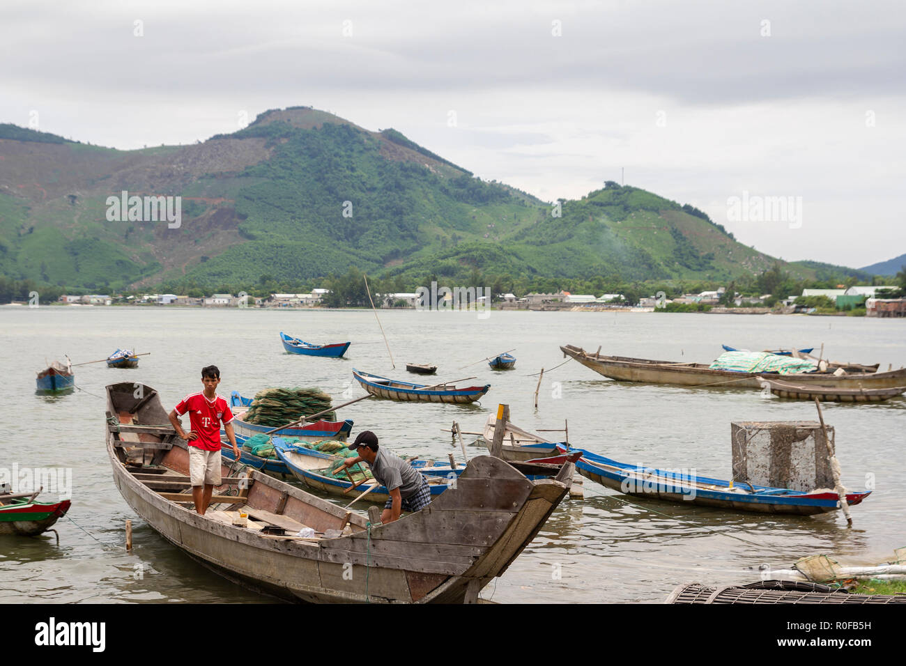 I pescatori la preparazione di barca di legno tradizionale per il viaggio di pesca in tinta, Vietnam Foto Stock