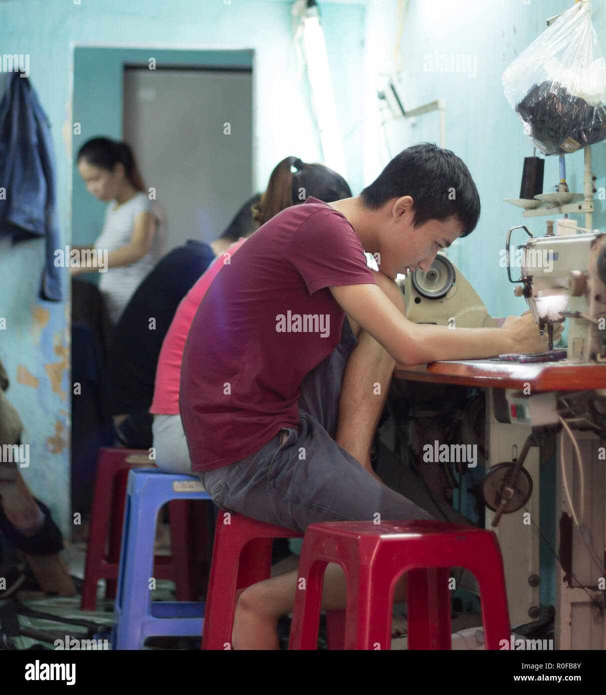 Sarto produrre panni dalla macchina da cucire in Hoi An, Vietnam. Foto Stock