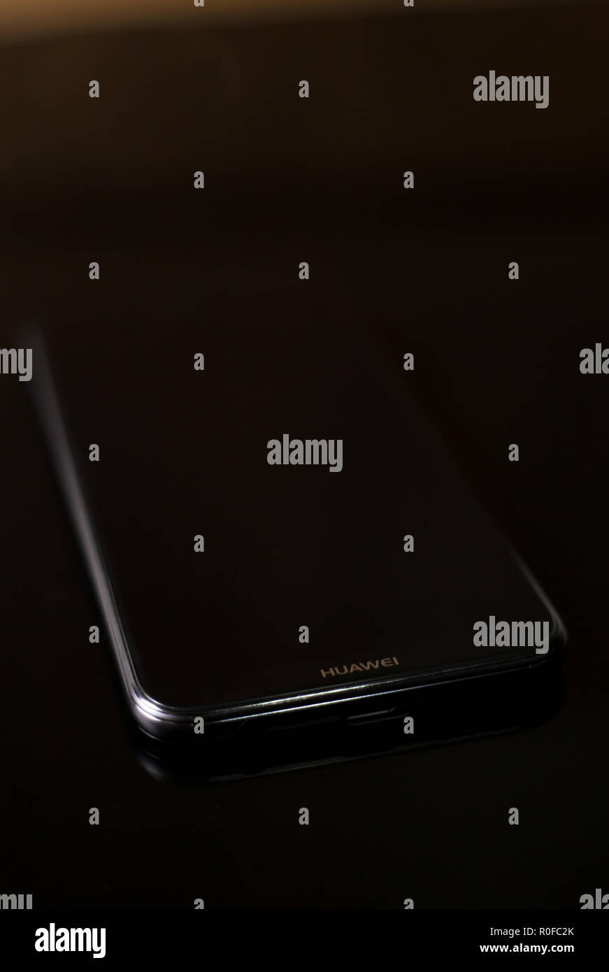 Lucido nuove P20 Lite telefono cellulare realizzato mediante tecnologia cinese marca Huawei liscio con bordi curvi su un Riflettente superficie nera Foto Stock