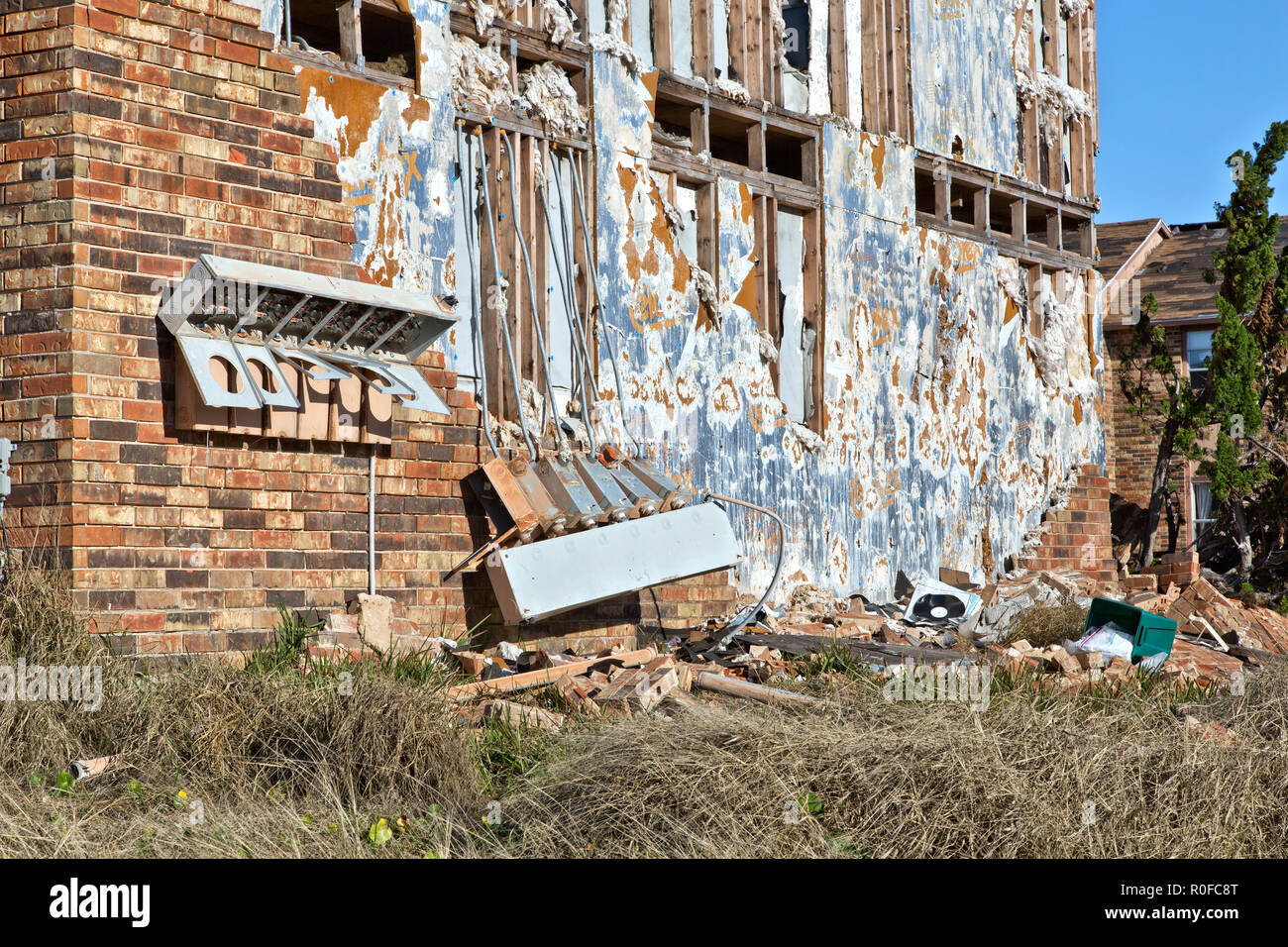 Muro esterno distrutto di Salt Grass Landing appartamenti, contatori elettrici e pannelli di controllo, staccati mattoni di fronte. Foto Stock