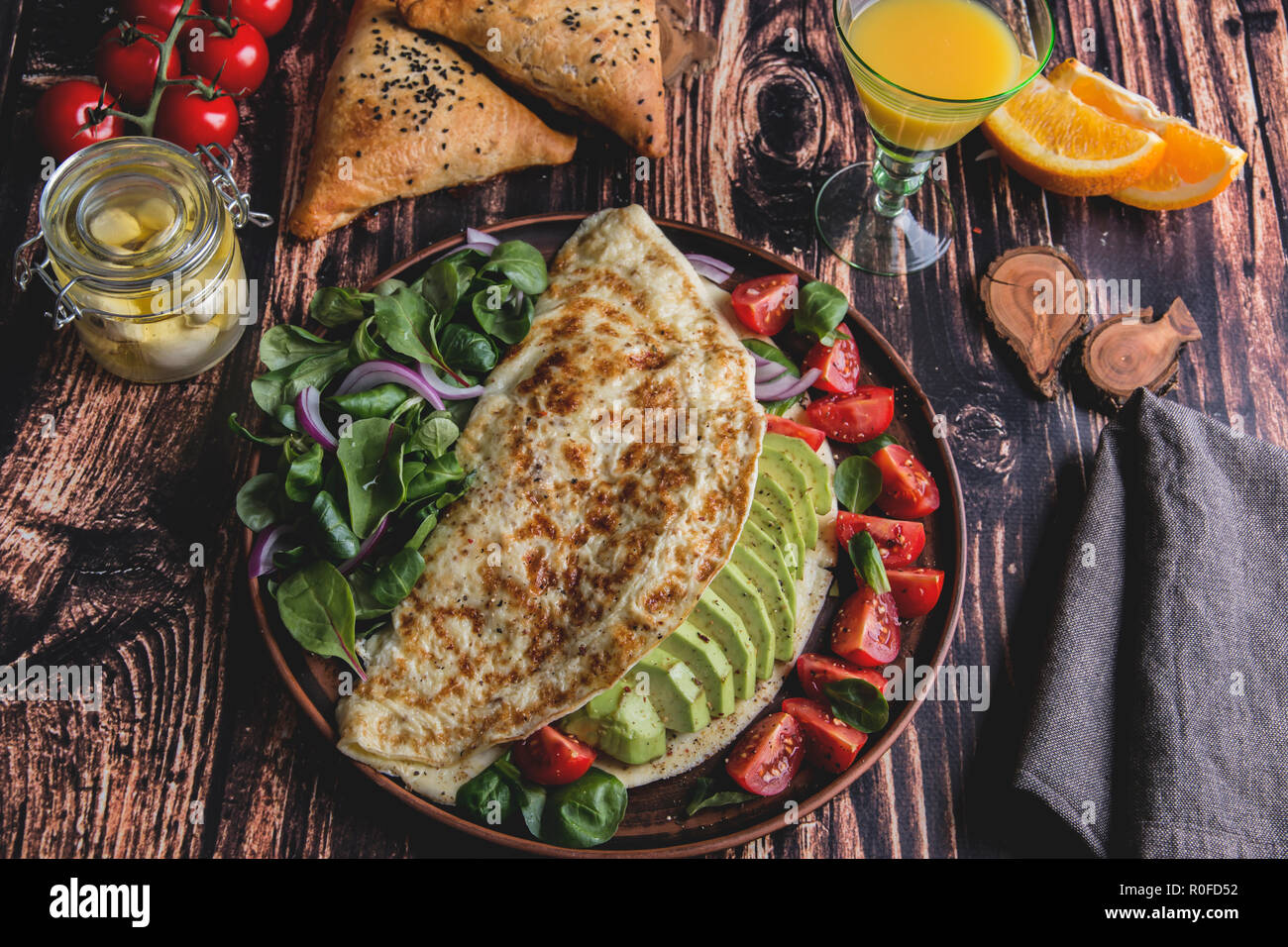 Frittata con avocado, pomodoro, mozzarella, succo di arancia, samsa. Cibo sano Foto Stock