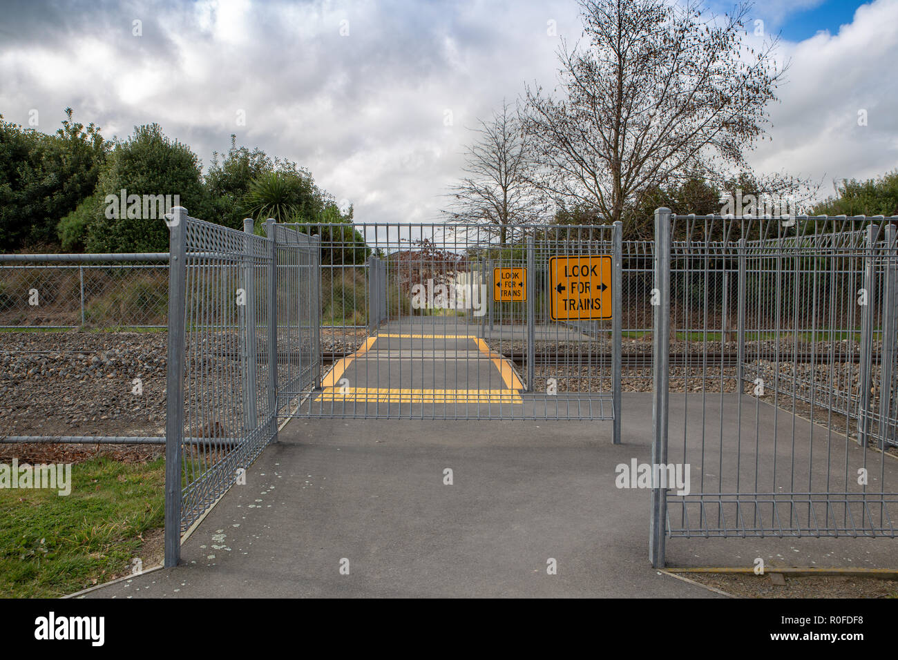 Barriere, linee gialle e segni in un percorso attraverso una via treno o la linea ferroviaria per la pubblica sicurezza Foto Stock