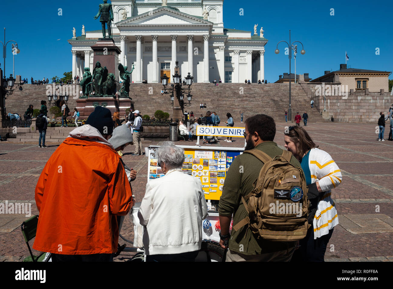 23.06.2018 - Helsinki, Finlandia, Europa - Toursits stand presso un negozio di souvenir in stallo sulla Piazza del Senato con la Cattedrale di Helsinki nel contesto. Foto Stock