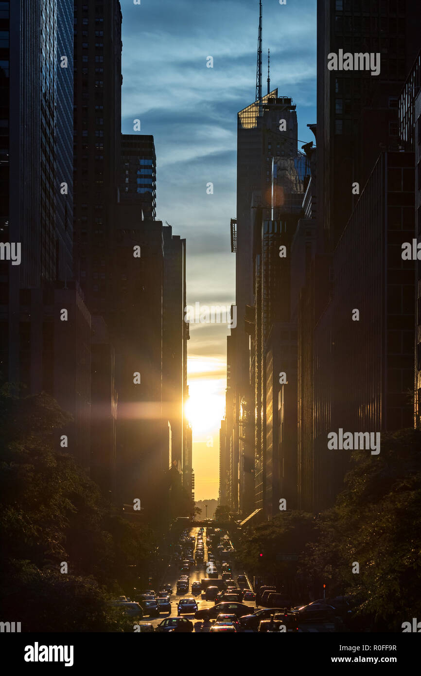 Tramonto tra gli edifici del centro cittadino di Manhattan con attraversate il traffico lungo la 42nd Street a New York City Foto Stock