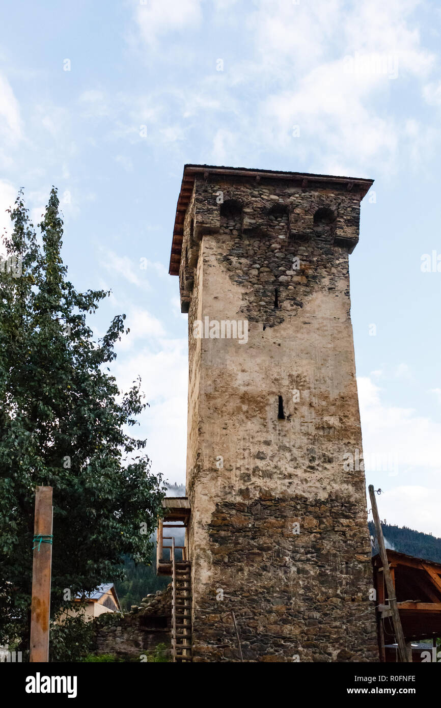 Antica pietra svan torre sulla strada di Mestia città in Svaneti, Georgia. Sky con nuvole di sfondo. Foto Stock