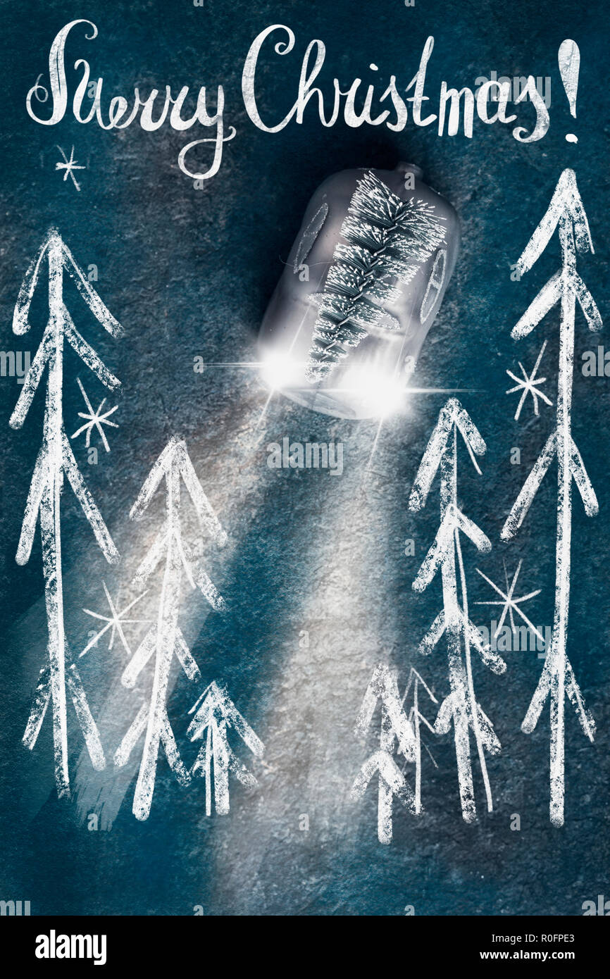 Albero di natale sul giocattolo auto con i fari anteriori con disegnato bosco di abete rosso e caratteri di testo su sfondo blu scuro, vista dall'alto con copia spazio per il vostro desig Foto Stock