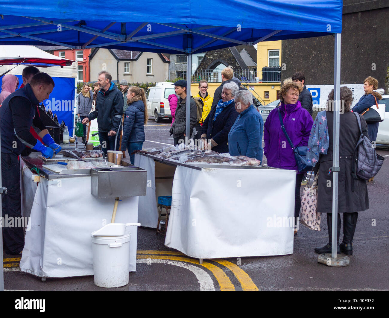 Gli amanti dello shopping l'acquisto di pesce fresco da un pescivendoli stallo in un paese mercato. Skibbereen, West Cork in Irlanda Foto Stock