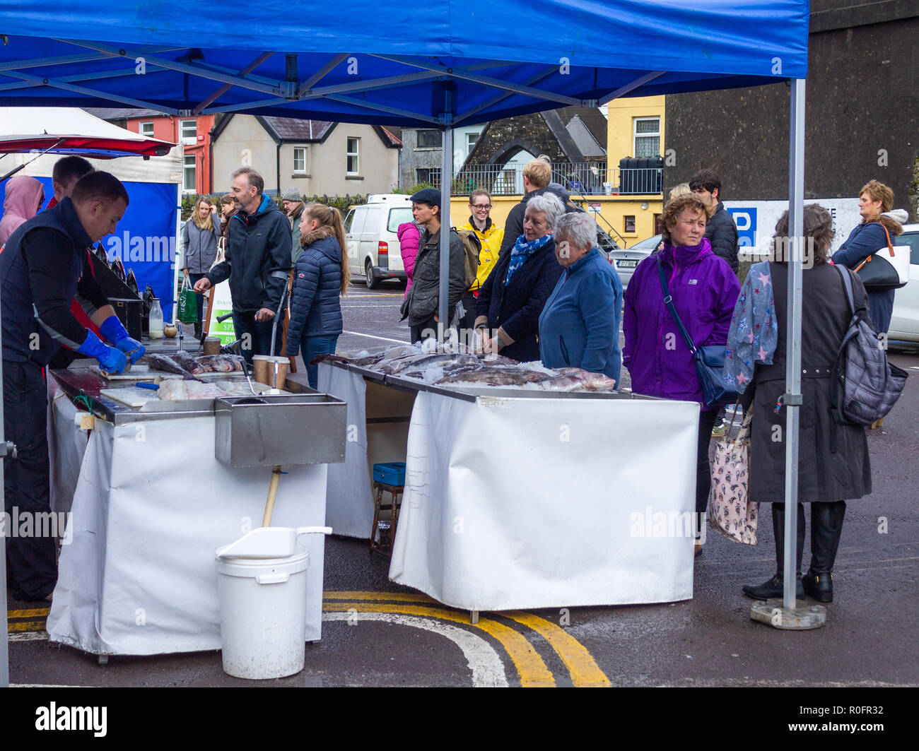 Gli amanti dello shopping l'acquisto di pesce fresco da un pescivendoli stallo in un paese mercato. Skibbereen, West Cork in Irlanda Foto Stock Gli amanti dello shopping l'acquisto di pesce fresco da un pescivendoli stallo in un paese mercato. Skibbereen, West Cork in Irlanda Foto Stock