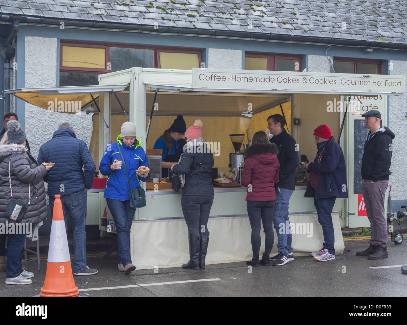 Gli amanti dello shopping in una coda per un caffè caldo e torte da uno stallo in un mercato alimentare di skibbereen West Cork in Irlanda. Foto Stock