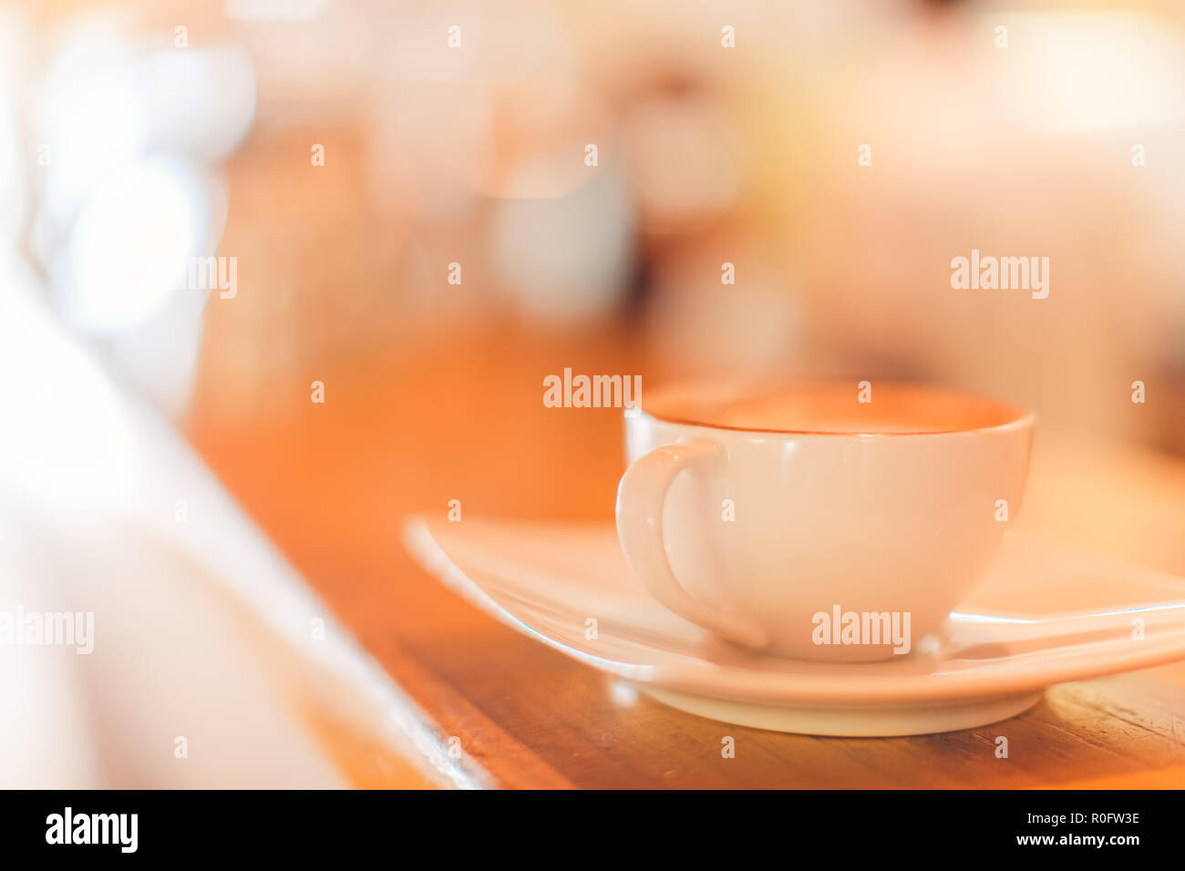 Arte a caldo latte caffè in una tazza sul tavolo di legno e la caffetteria di sfocatura con sfondo bokeh di fondo dell'immagine. Latte Art tavolino vista superiore, felice atmosfera rilassante Foto Stock
