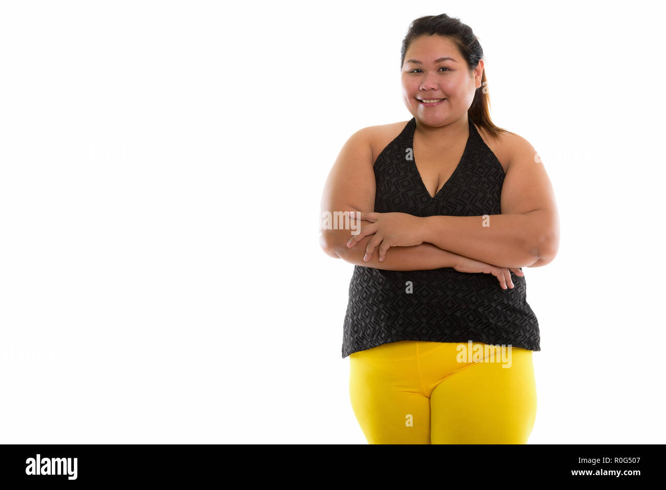 Studio shot di giovani felici fat Asian donna sorridente con bracci cro Foto Stock