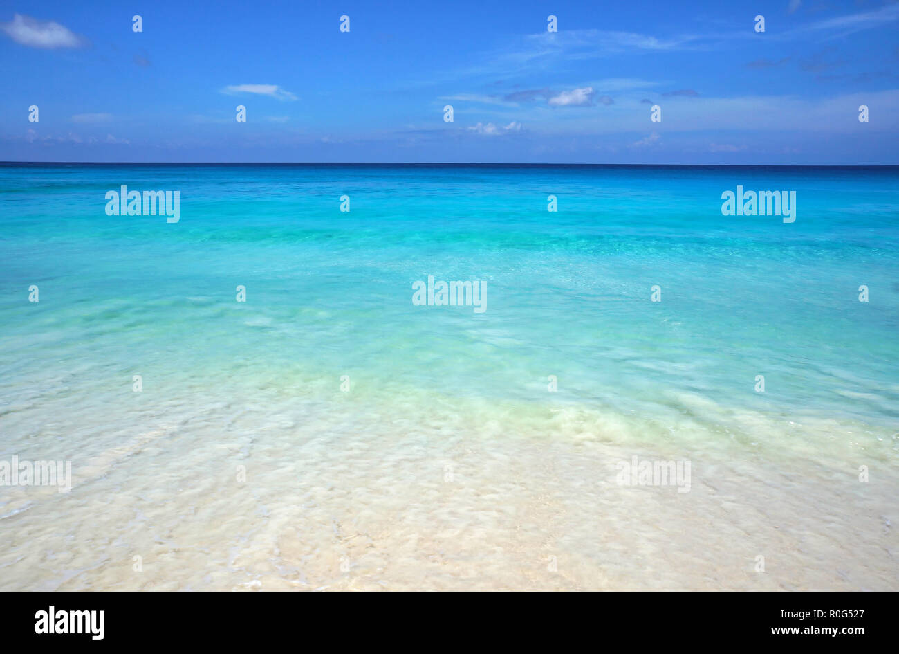 Scenic seascape di azzurro Oceano trasparente acqua e cielo blu. Spiaggia tropicale con sabbia bianca. Scenario idilliaco della località balneare. Viaggi esotici destin Foto Stock