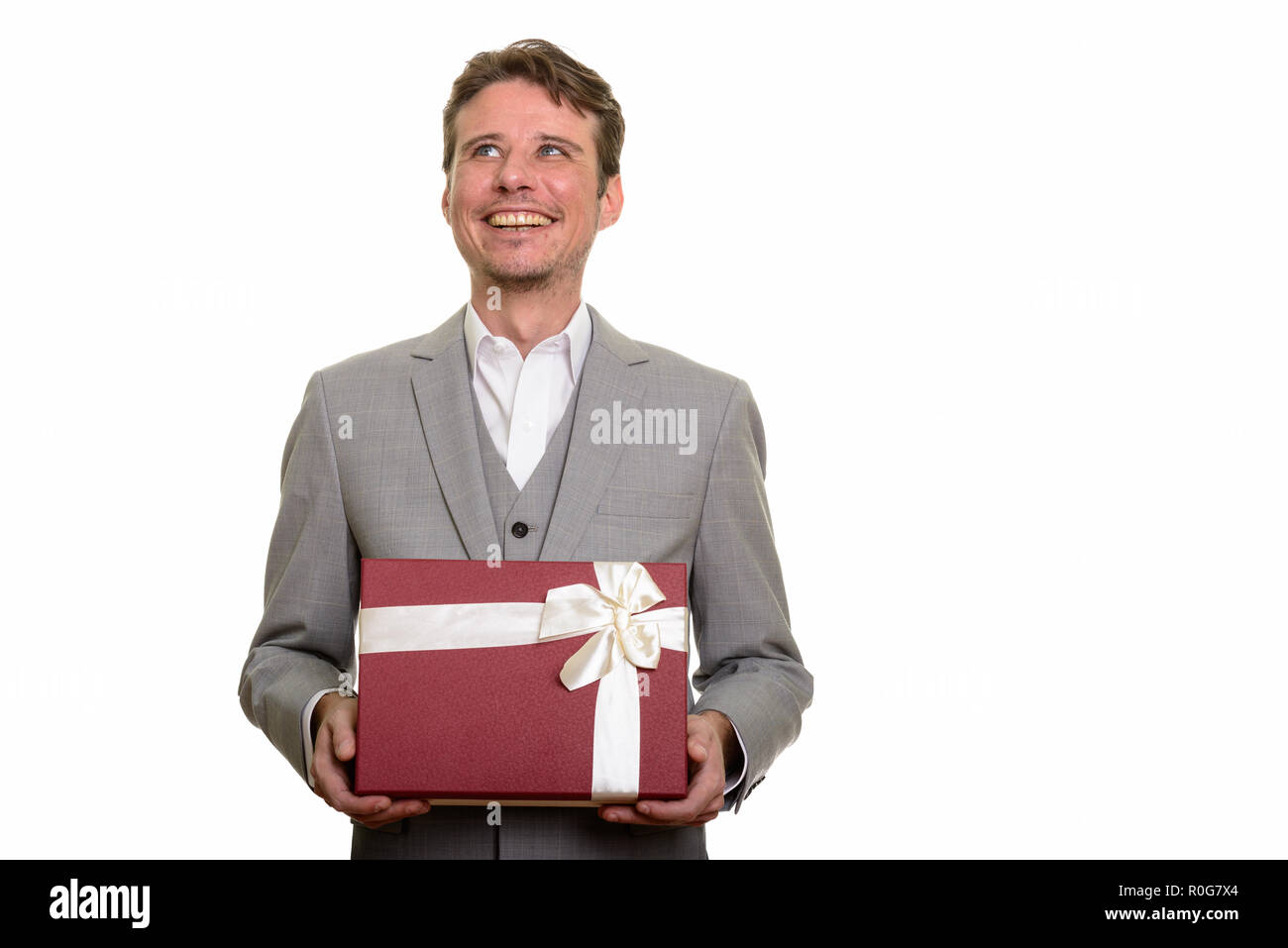 Happy businessman caucasica pensando tenendo confezione regalo leggi Foto Stock