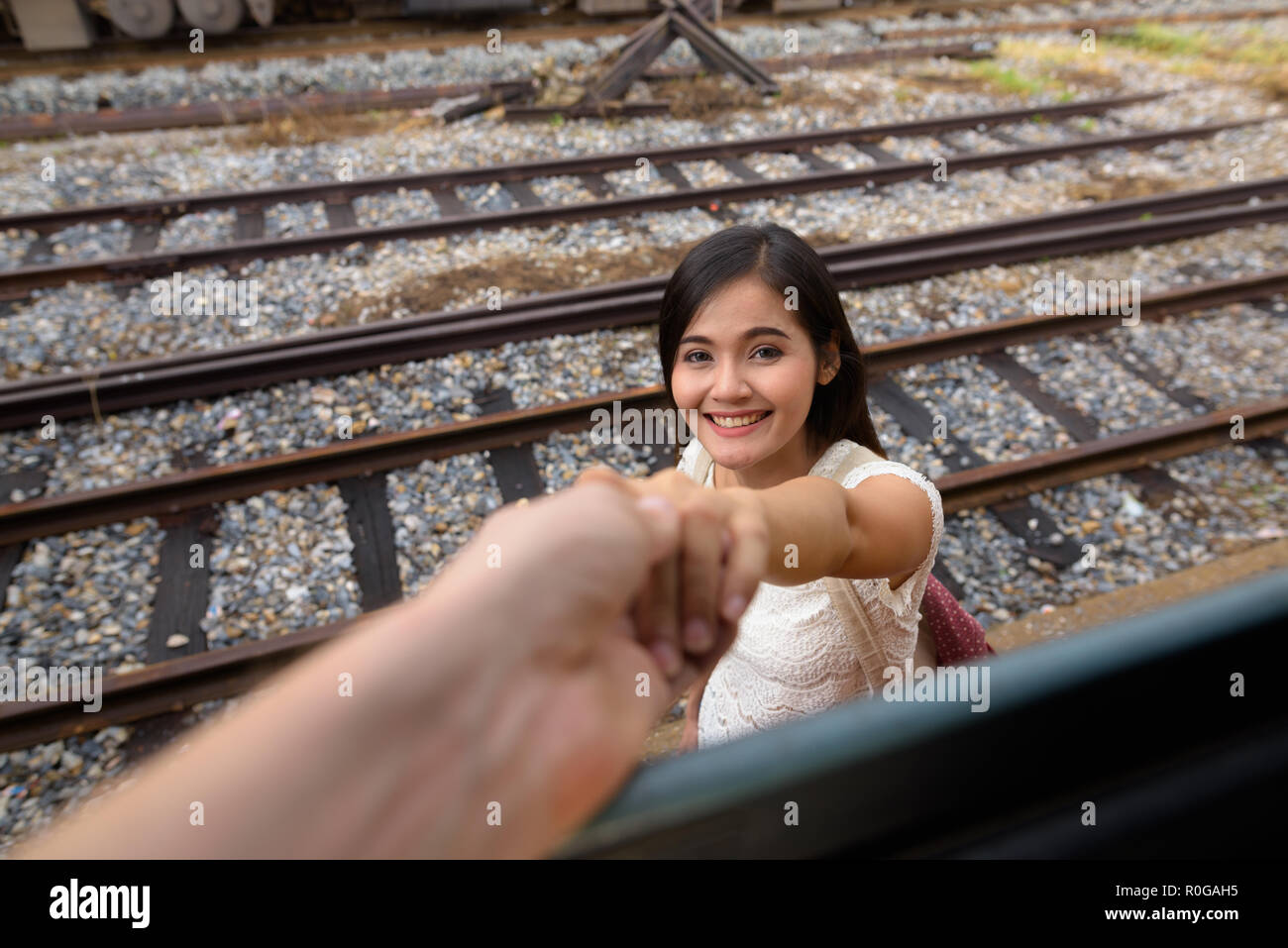 Bella donna tenendo la mano dell'uomo passeggero in treno Foto Stock