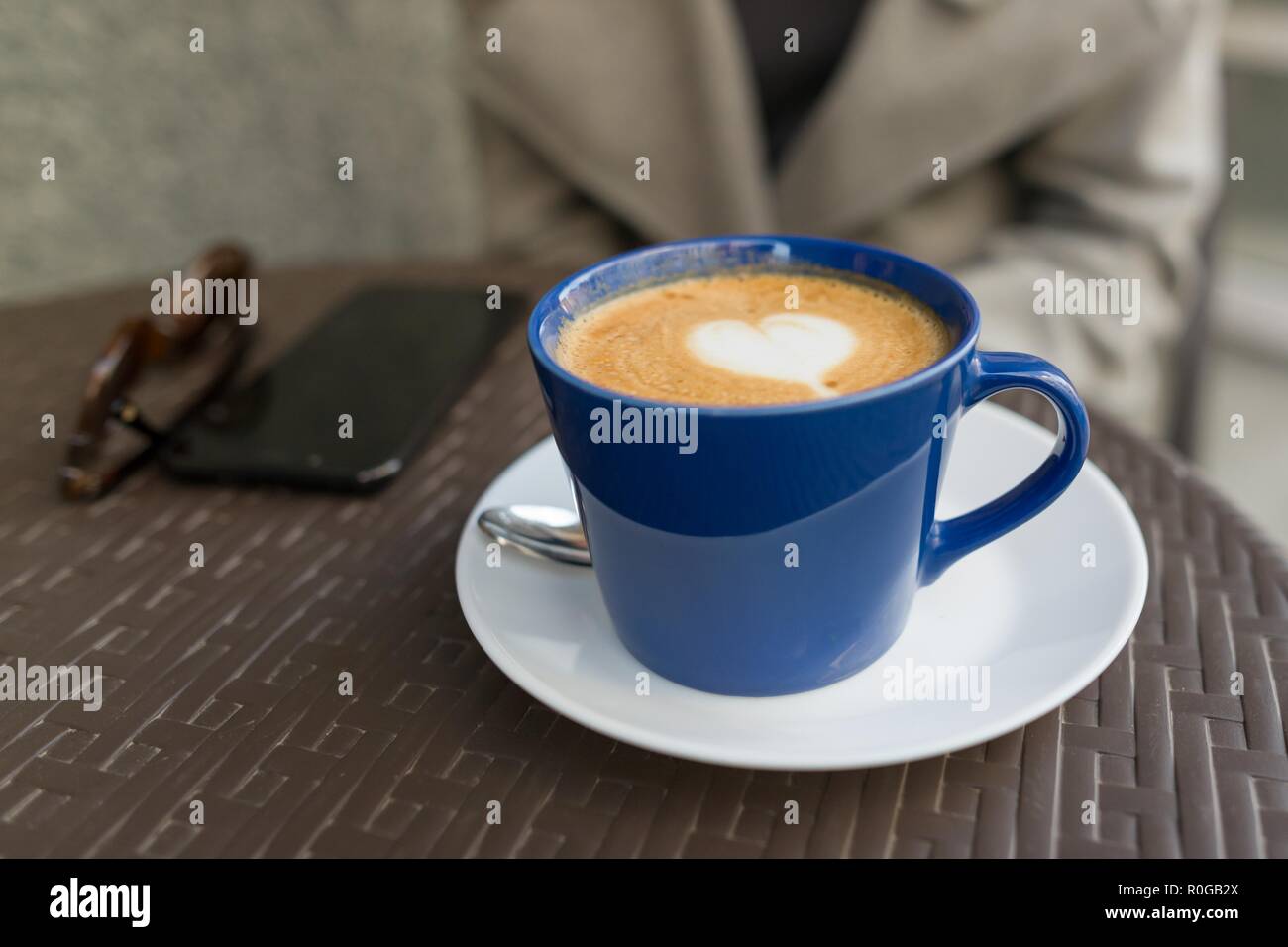 Blu con tazza cappuccino, su un tavolo in street cafe, il disegno di un  cuore Foto stock - Alamy