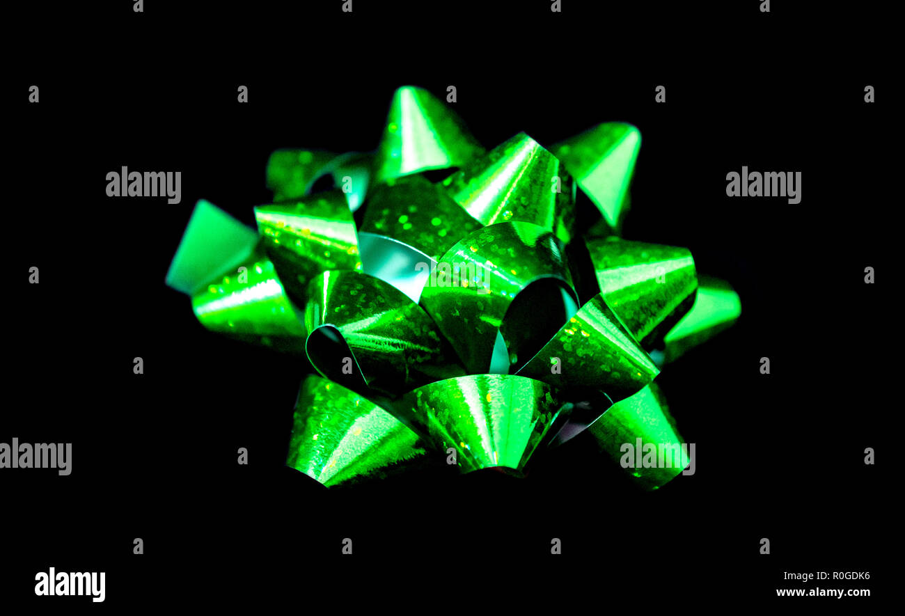 Un (1) Natale in Satin Ribbon - Satin di colore verde su sfondo nero. Camera per copia. Foto Stock
