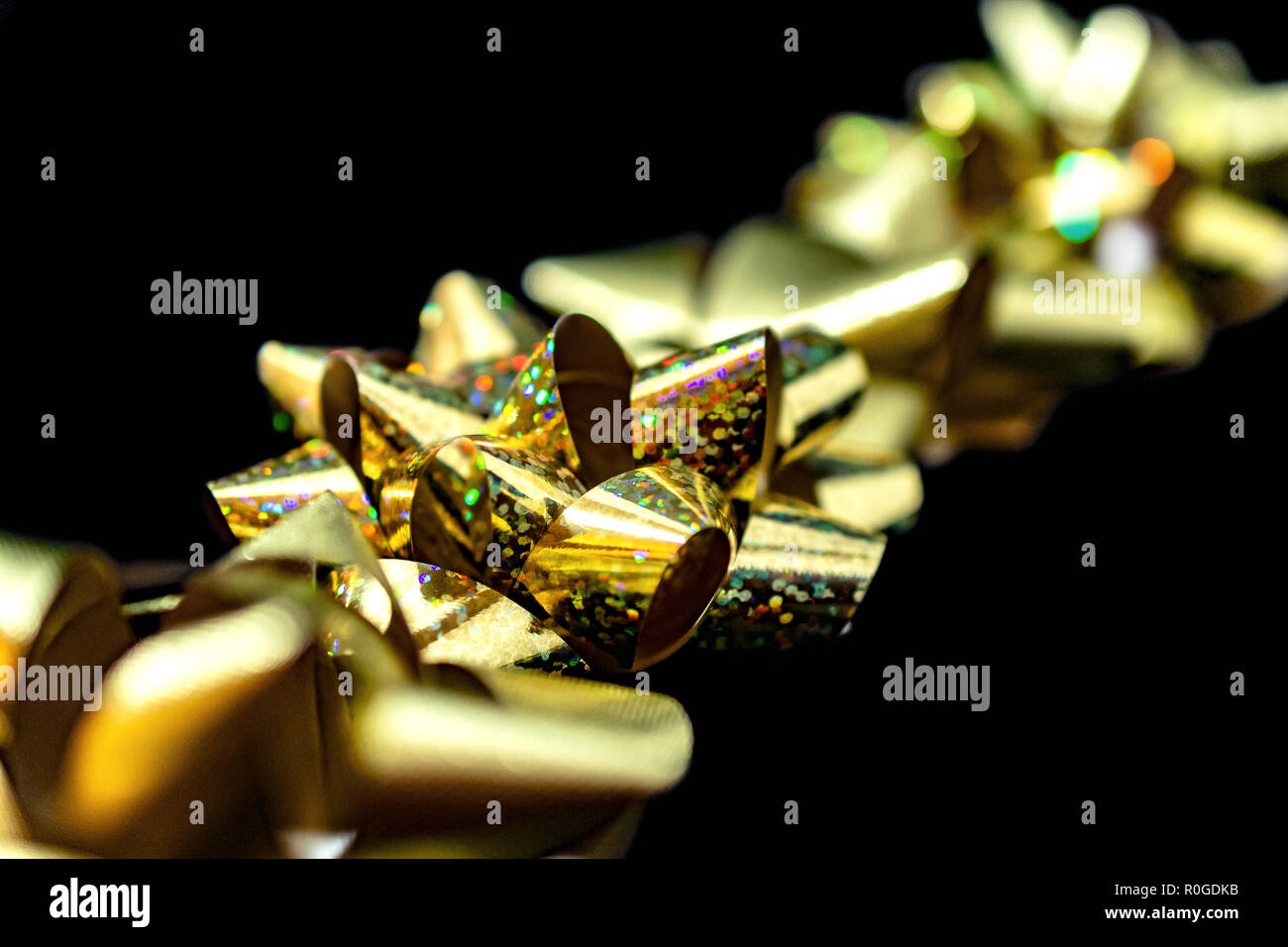 Vacanze di Natale in satin nastri, color oro su sfondo nero. Camera per copia. Vividi e brillanti colori. Foto Stock