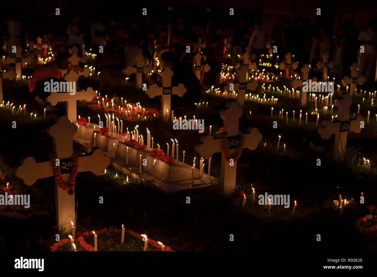 Migliaia di candele sul cimitero accanto a San Giovanni della chiesa di Gazipur Tumulia per osservare il giorno della commemorazione di tutti i defunti, una giornata di preghiera per i defunti. Tumul Foto Stock