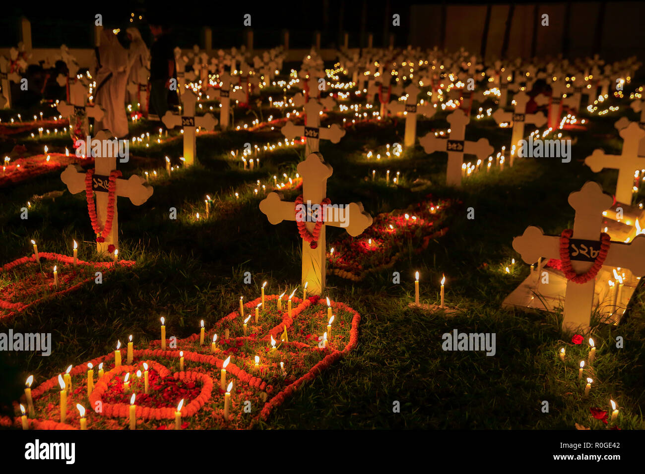 Migliaia di candele sul cimitero accanto a San Giovanni della chiesa di Gazipur Tumulia per osservare il giorno della commemorazione di tutti i defunti, una giornata di preghiera per i defunti. Tumul Foto Stock