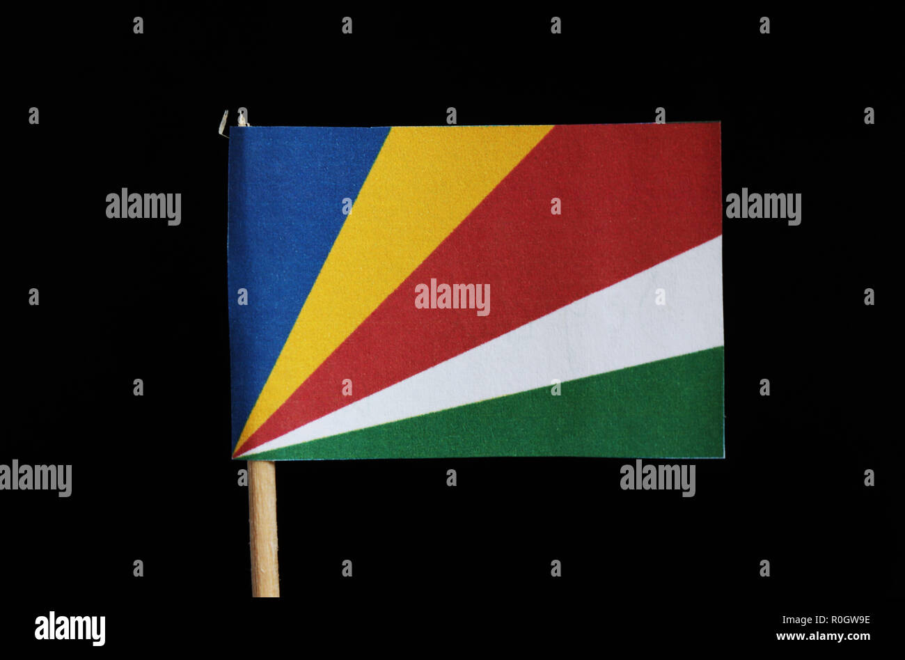 Una bandiera nazionale delle Seicelle su stuzzicadenti su sfondo nero. È  costituito da cinque fasce oblique di blu, giallo, rosso, bianco e verde  che si irradiano da Foto stock - Alamy