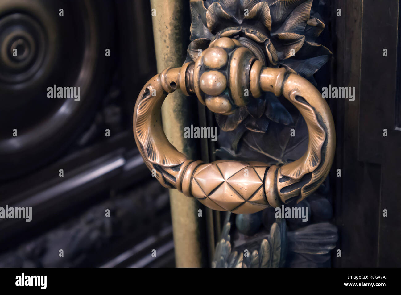 Antico Bronzo figurato manopola dello sportello su una massiccia scolpita porta in legno Foto Stock