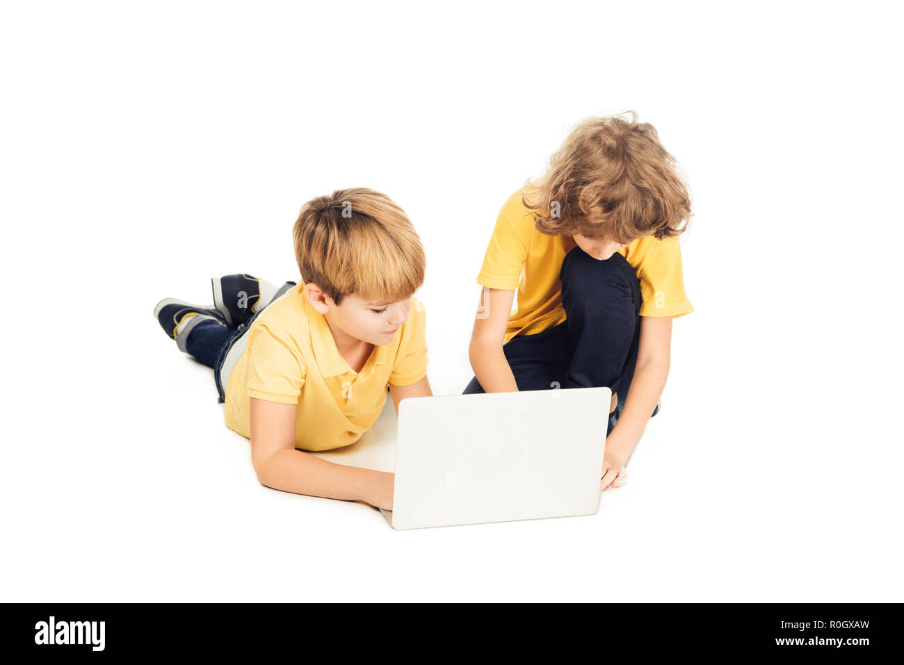 Simpatici ragazzi utilizzando laptop insieme isolato su bianco Foto Stock
