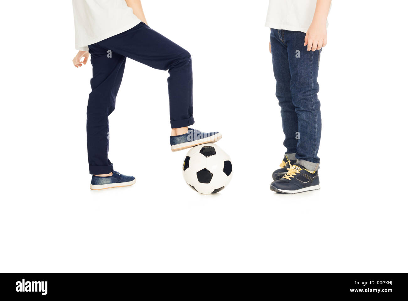 Immagine ritagliata di ragazzi giocare con palla calcio isolato su bianco Foto Stock