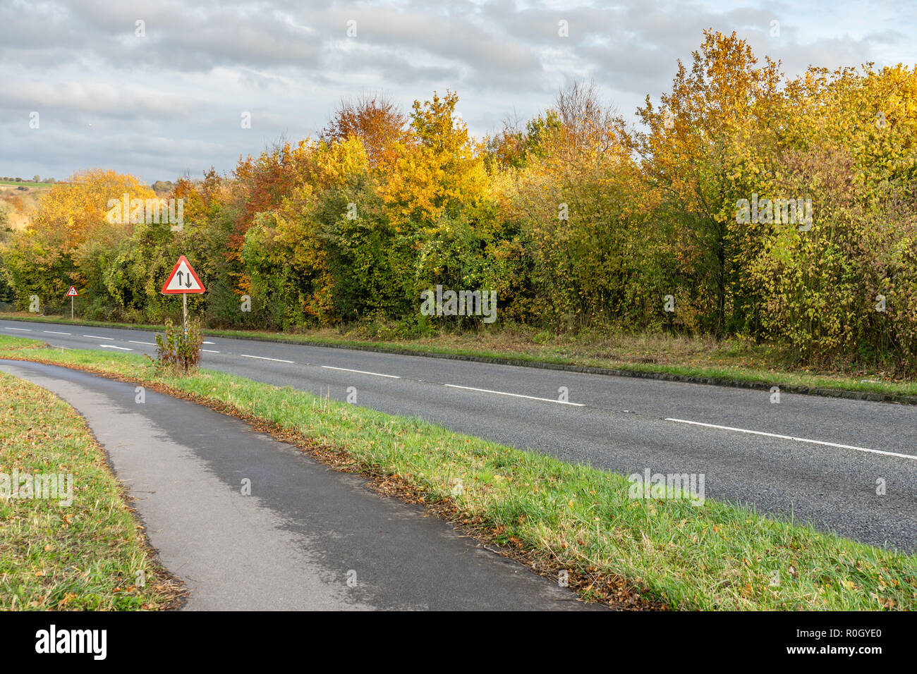 In autunno, Inghilterra, Regno Unito, segnaletica stradale a due vie avanti su una strada del Regno Unito Foto Stock