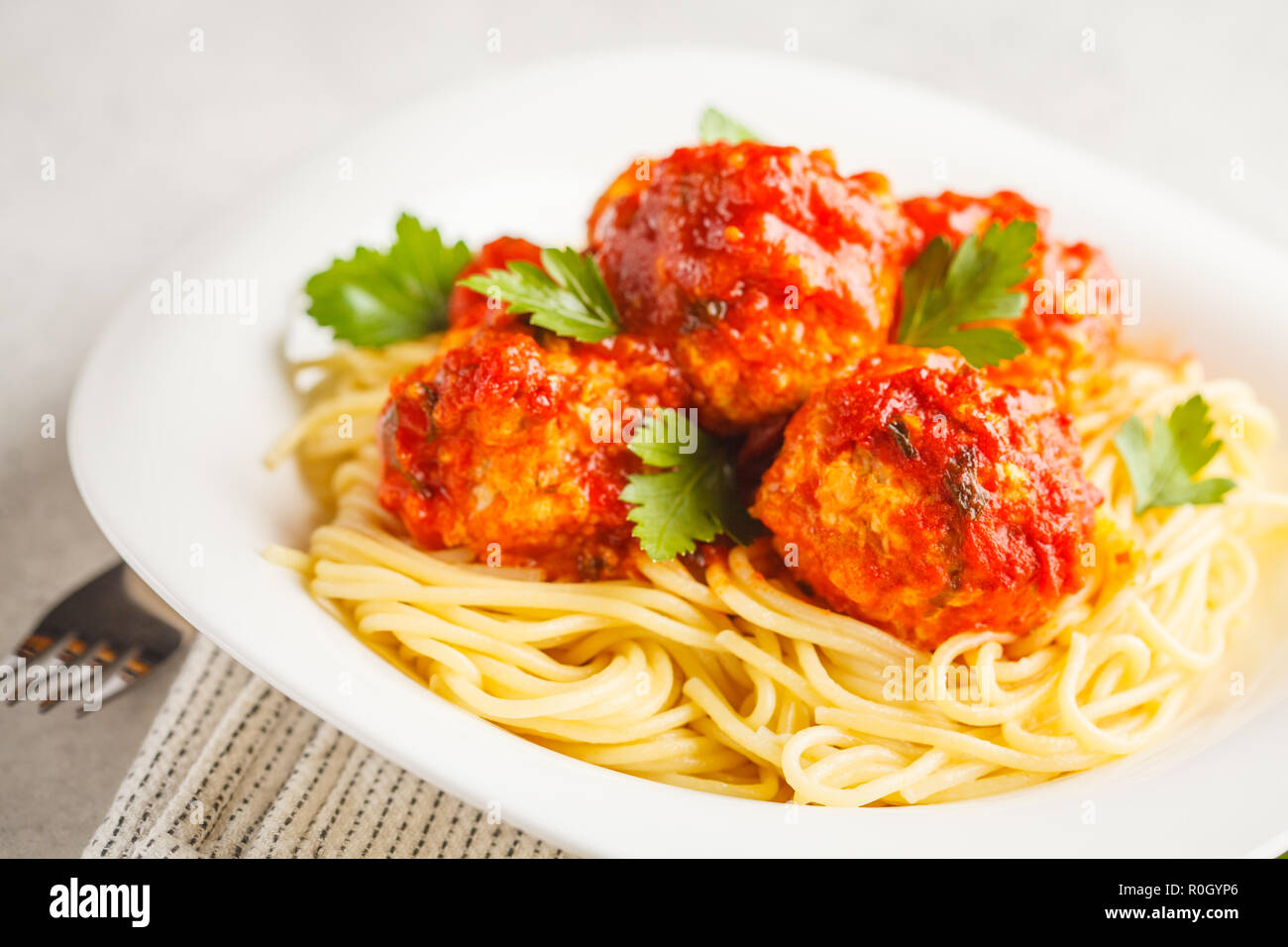 Polpette di pollo con salsa di pomodoro e gli spaghetti al dente in una  piastra bianca, sfondo bianco Foto stock - Alamy