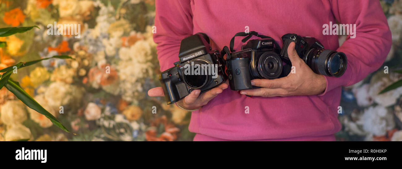 Fotografo azienda tre fotocamere Foto Stock
