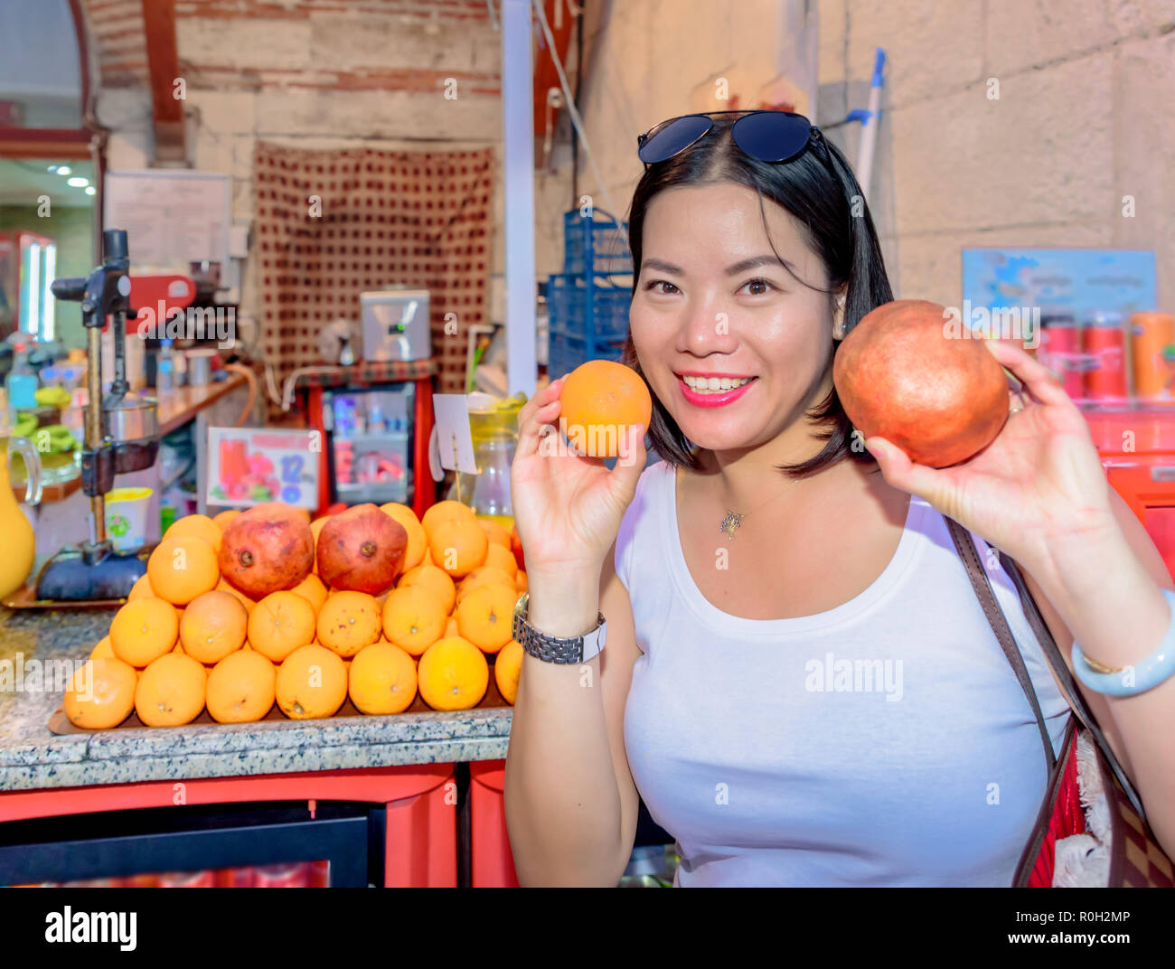 Bella donna mostra frutti nella parte anteriore del succo di frutta in stallo in Istanbul, Turchia Foto Stock