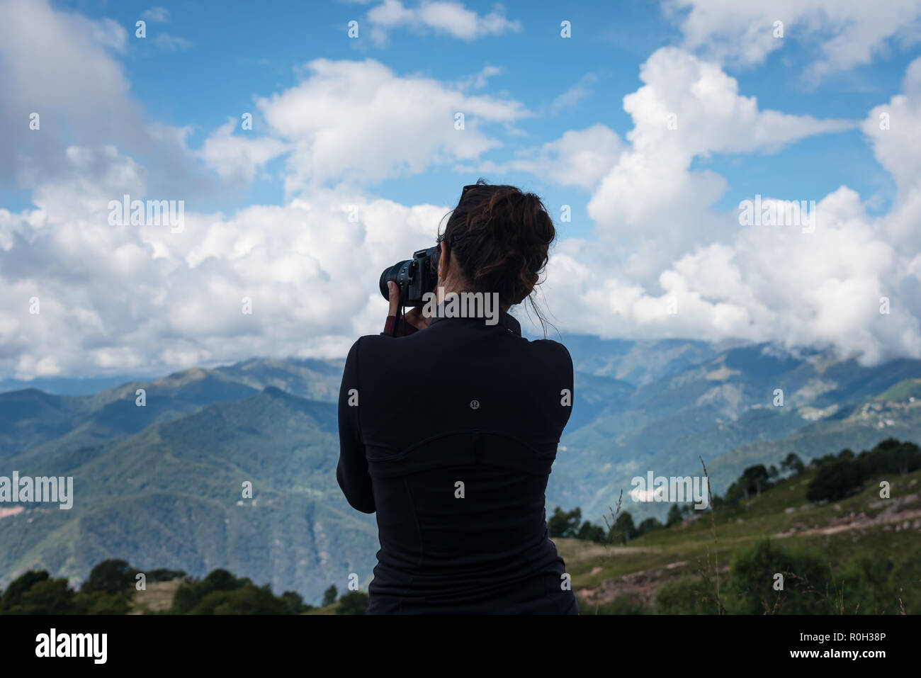 Una giovane ragazza prende una fotografia di montagna Foto Stock