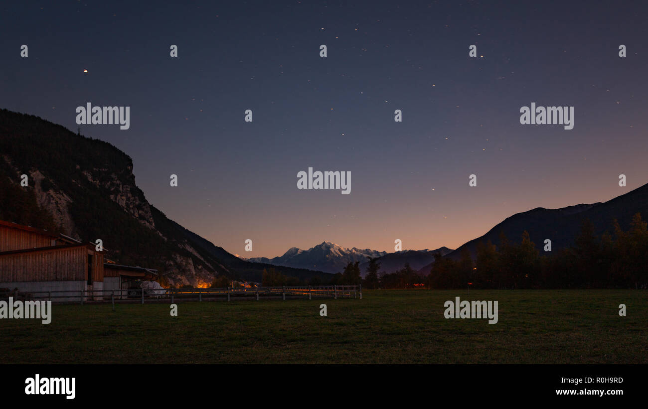 Cielo notturno fattoria vista in Curon Venosta, Alto Adige, Italia Foto Stock
