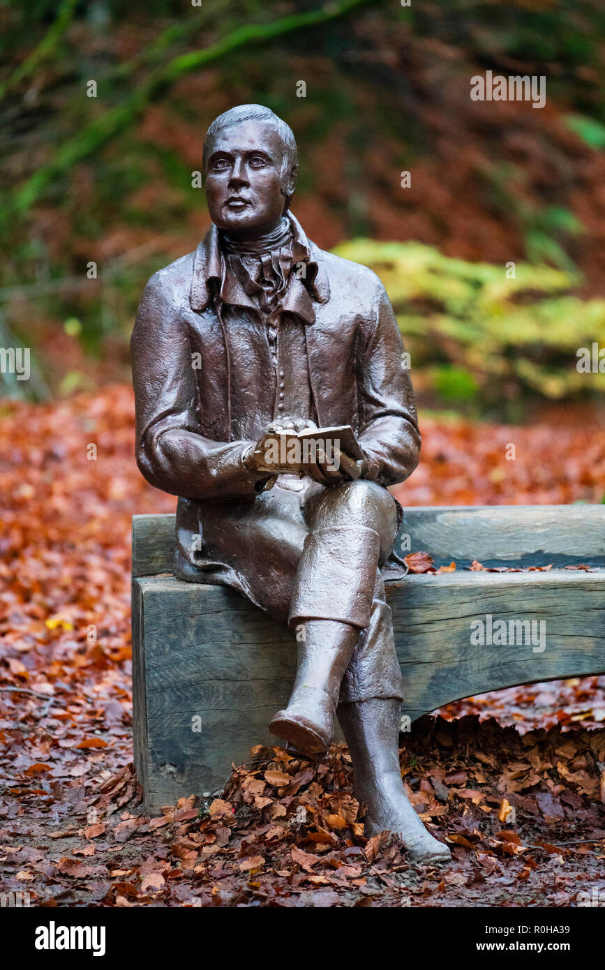 Statua del poeta Robert Burns si siede sul banco durante l autunno a Birks O'Aberfeldy scenic area a Aberfeldy, Perthshire Scozia,UK Foto Stock