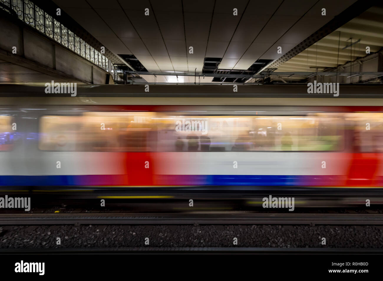 Velocizzando il treno arrivando alla piattaforma sulla metropolitana di Londra la stazione della metropolitana Foto Stock