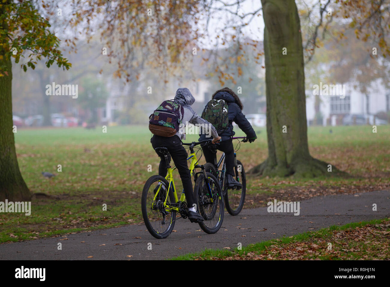 Northampton, Regno Unito. 5 Novembre, 2018. Due ragazzi rendendo tutto a scuola con le loro mountain bike attraverso Abington Park in una fredda mattina nebbiosa, meteo dovrebbe essere il miglioramento più tardi nella giornata. Credito: Keith J Smith./Alamy Live News Foto Stock