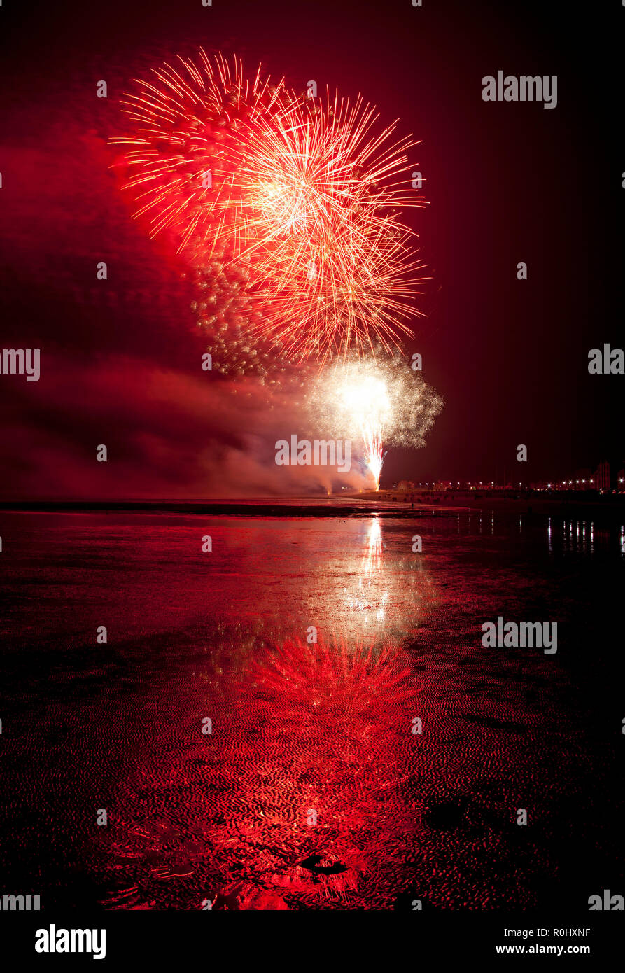 Musselburgh, Scozia, Regno Unito, 5 nov. 2018. Guy Fawkes fuochi d'artificio riflessa nella sabbia bagnata. Insolitamente mite a 9 gradi per la East Lothian town annuale gratis Fireworks display a cui hanno partecipato anche a più persone a causa della chiusura di Edimburgo di Meadowbank Stadium. Foto Stock