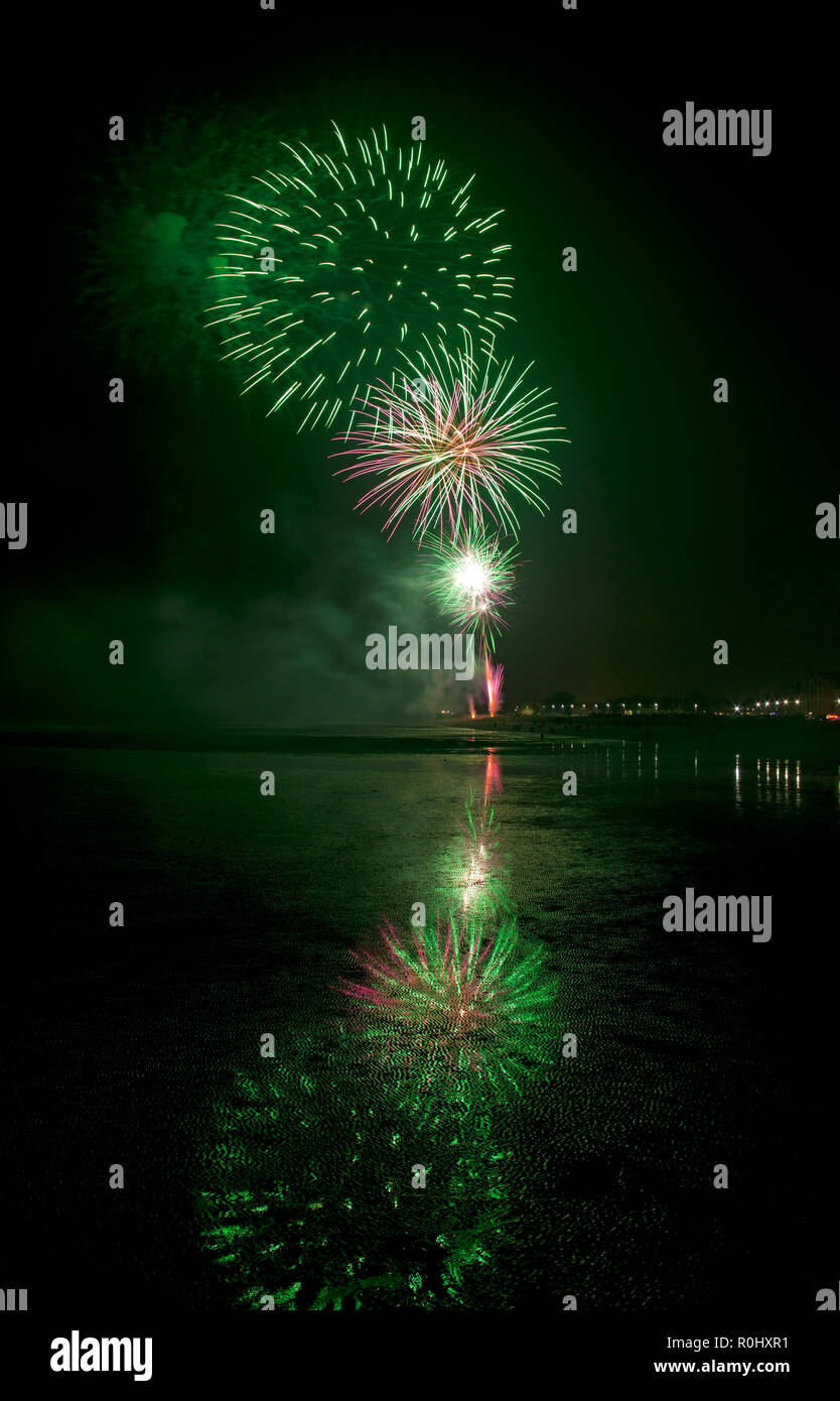 Musselburgh, Scozia, Regno Unito, 5 nov. 2018. Guy Fawkes fuochi d'artificio riflessa nella sabbia bagnata. Insolitamente mite a 9 gradi per la East Lothian town annuale gratis Fireworks display a cui hanno partecipato anche a più persone a causa della chiusura di Edimburgo di Meadowbank Stadium. Foto Stock