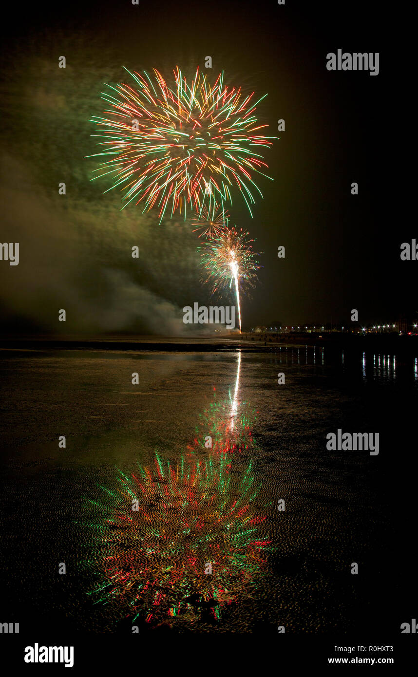 Musselburgh, Scozia, Regno Unito, 5 nov. 2018. Guy Fawkes fuochi d'artificio riflessa nella sabbia bagnata. Insolitamente mite a 9 gradi per la East Lothian town annuale gratis Fireworks display a cui hanno partecipato anche a più persone a causa della chiusura di Edimburgo di Meadowbank Stadium. Foto Stock