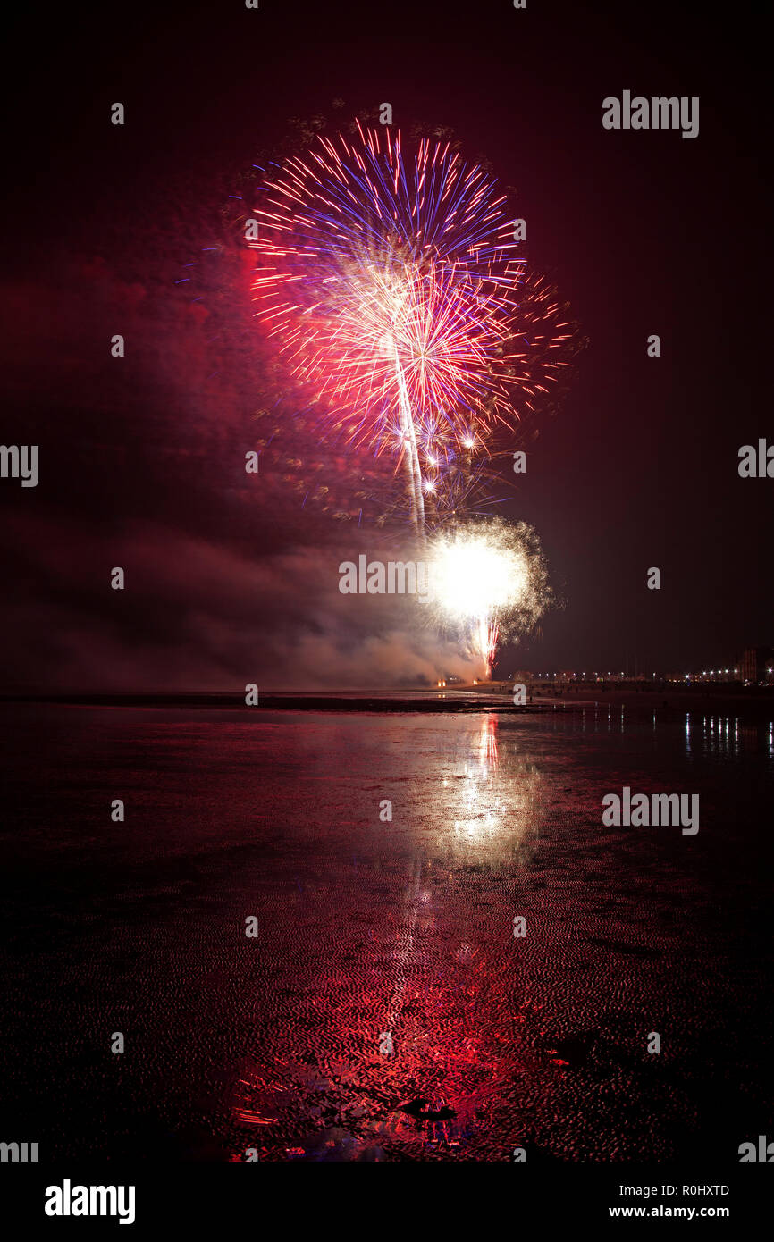 Musselburgh, Scozia, Regno Unito, 5 nov. 2018. Guy Fawkes fuochi d'artificio riflessa nella sabbia bagnata. Insolitamente mite a 9 gradi per la East Lothian town annuale gratis Fireworks display a cui hanno partecipato anche a più persone a causa della chiusura di Edimburgo di Meadowbank Stadium. Foto Stock