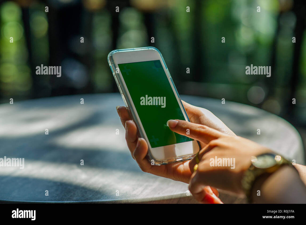La vista ritagliata della donna mano azienda uno smart phone con una schermata vuota per il testo dello spazio del messaggio o il contenuto del messaggio di testo di lettura su un mobile p Foto Stock