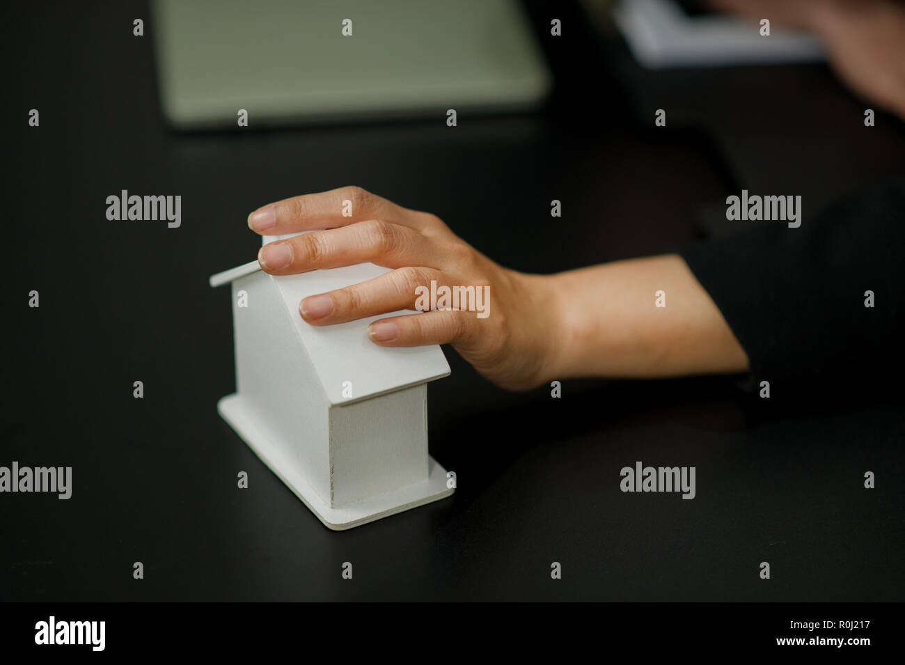 Mano e i lavoratori a domicilio il sogno di duro lavoro per avere una casa dopo l. Possedere una casa bianca. Foto Stock