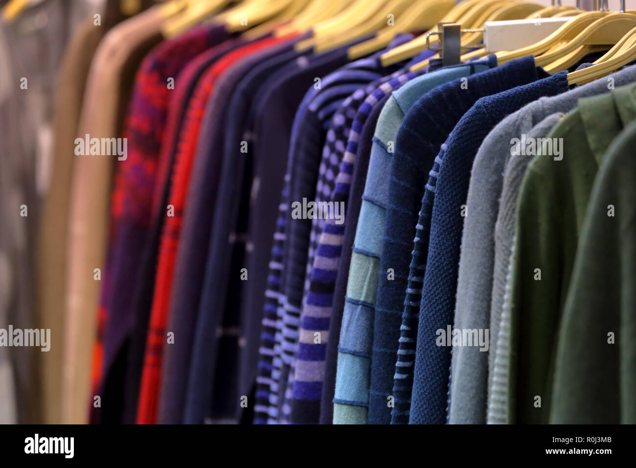 Una fila di abiti da donna su un appendiabiti in un negozio per la vendita Foto Stock