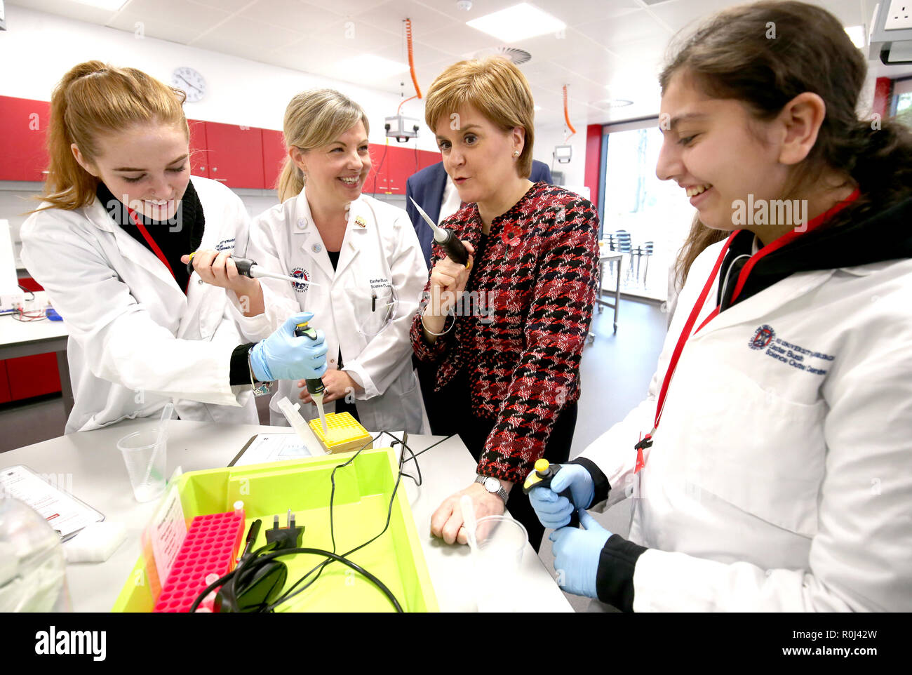 Primo Ministro Nicola Storione utilizza un micro pipetta a fianco di studenti da Musselburgh Grammar School durante un laboratorio di biologia fuori-raggiungere la lezione del Roslin Innovation Center presso l Università di Edimburgo, Pasqua Bush Campus, Midlothian. Foto Stock