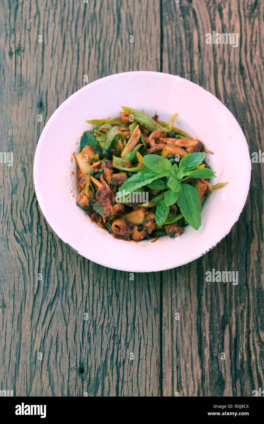 Mescolare le spezie con tropici anguilla nel piatto bianco sul pavimento in legno,cibo locale è stato popolare in Thailandia. Foto Stock