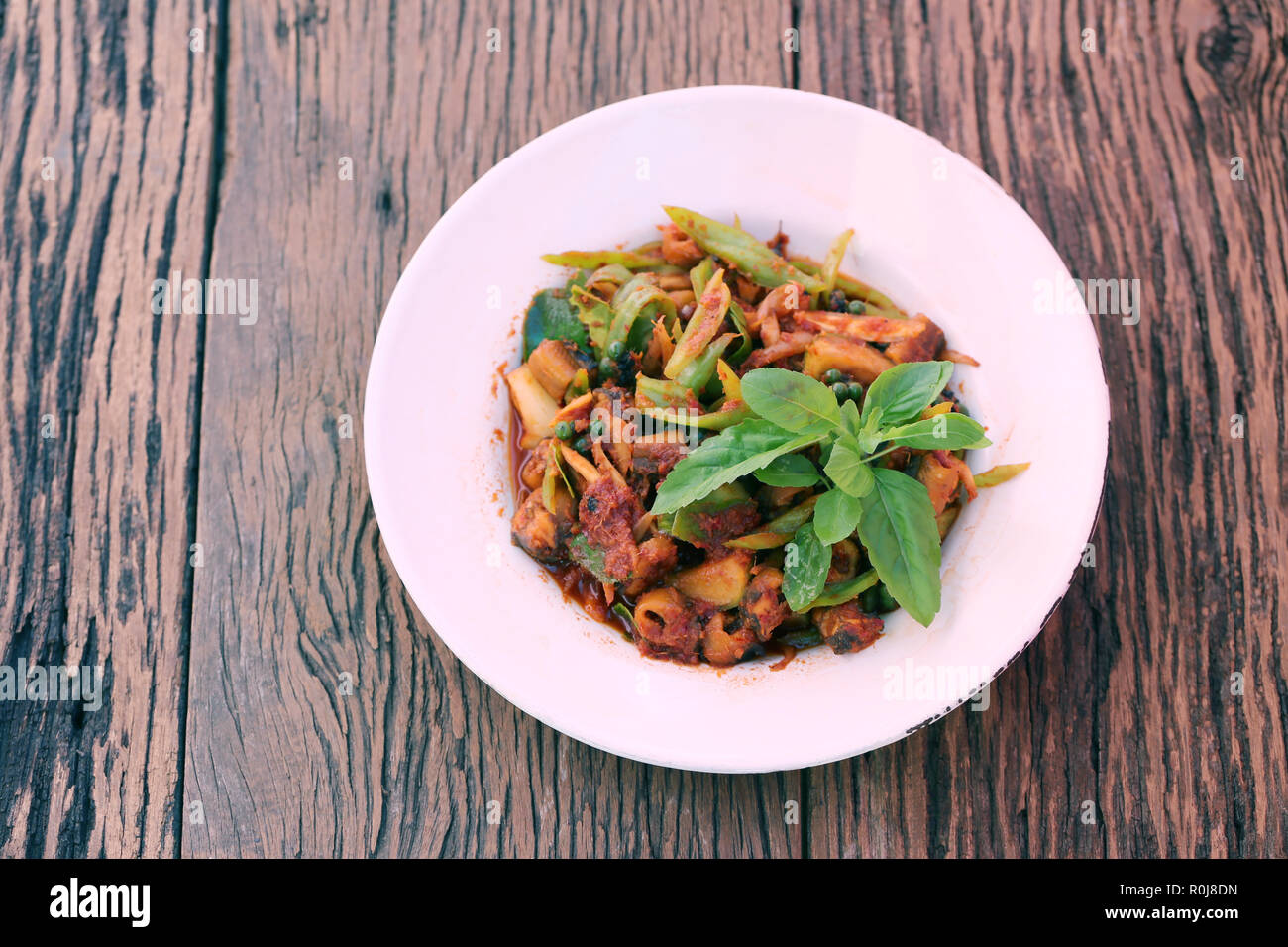 Mescolare le spezie con tropici anguilla nel piatto bianco sul pavimento in legno,cibo locale è stato popolare in Thailandia. Foto Stock