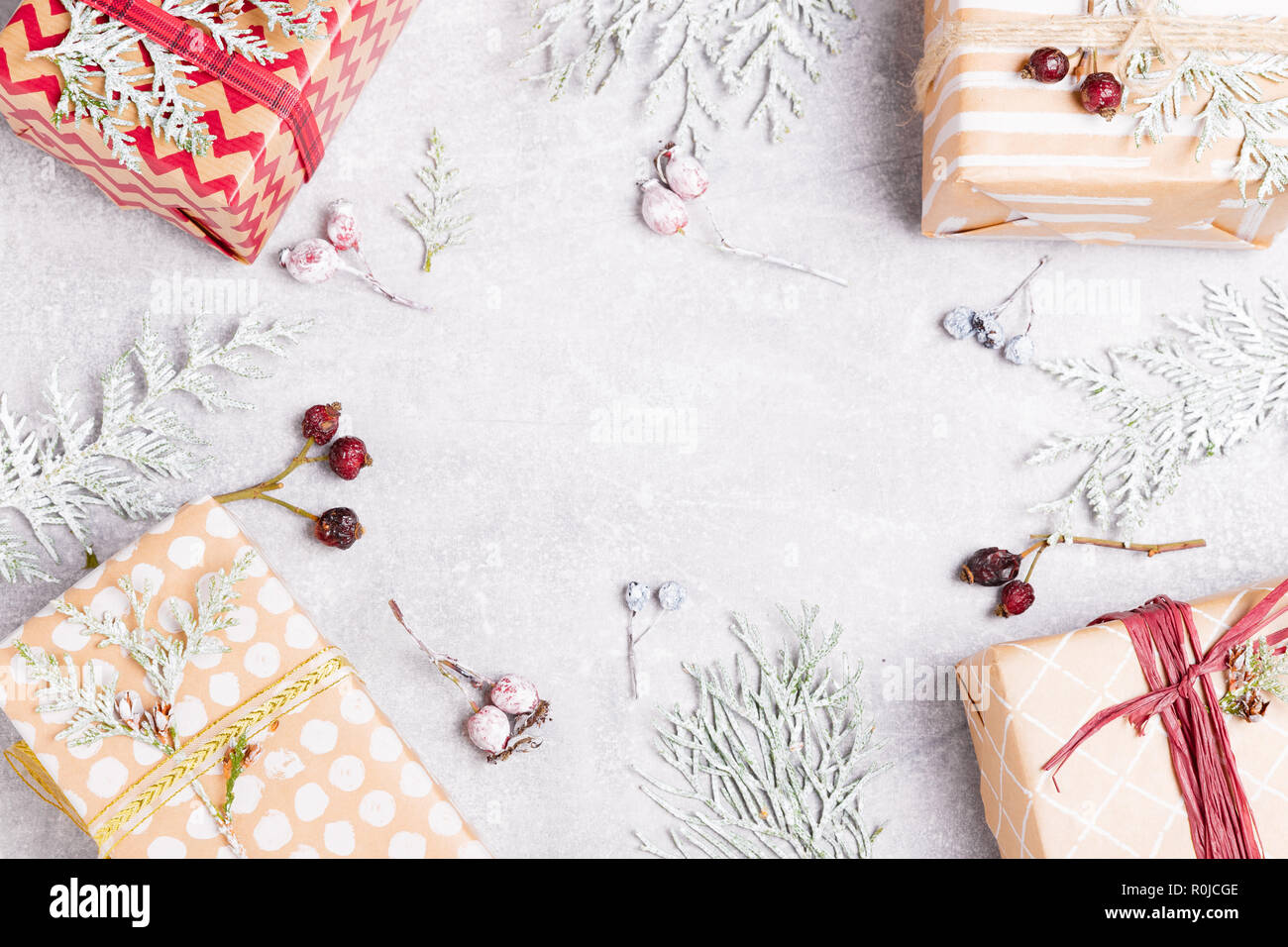 Composizione di natale con un regalo di Natale, thuja rami e bacche di rosa canina. Vista superiore, piana, laici copia spazio. Foto Stock