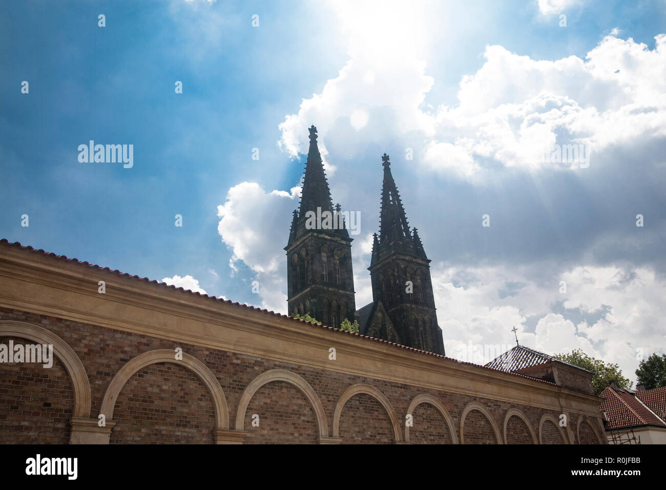 Praga, Repubblica Ceca - 14 Luglio 2018: un muro del cimitero e la torre campanaria della Basilica di San Pietro e Paolo a Vysehrad Foto Stock
