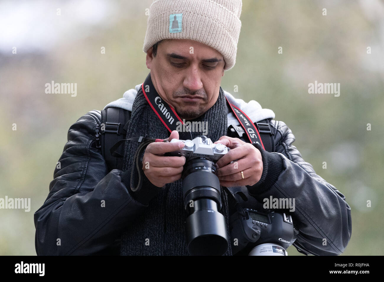 Fotografo con due telecamere guardando le immagini sul display LCD sul retro della fotocamera Foto Stock
